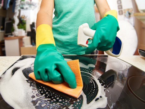 Upholstery cleaner treating stains during sofa cleaning in Falconwood